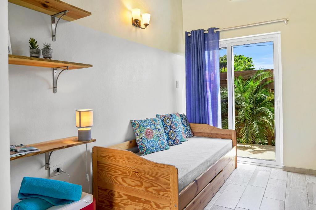 sypialnia z łóżkiem i oknem z widokiem w obiekcie Anaté Beach Apartments, Mangel Alto w mieście Savaneta
