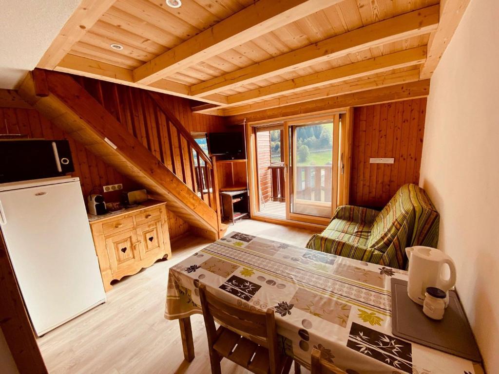 - une cuisine avec une table et un réfrigérateur dans la chambre dans l'établissement Duplex au cœur du village avec balcon et garage à La Clusaz, proche des pistes et commodités - FR-1-459-216, à La Clusaz