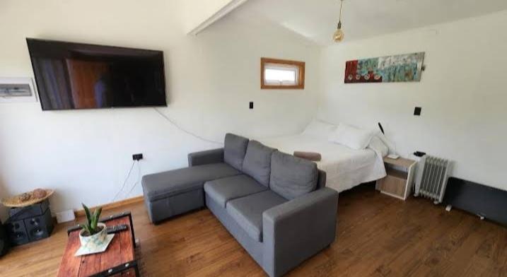 a living room with a couch and a bed at Cabaña / loft in Puerto Montt