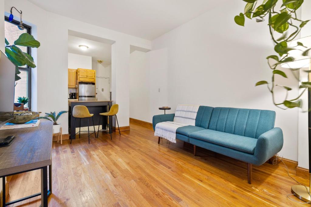 a living room with a blue couch and a kitchen at Central Living at Columbia university in New York