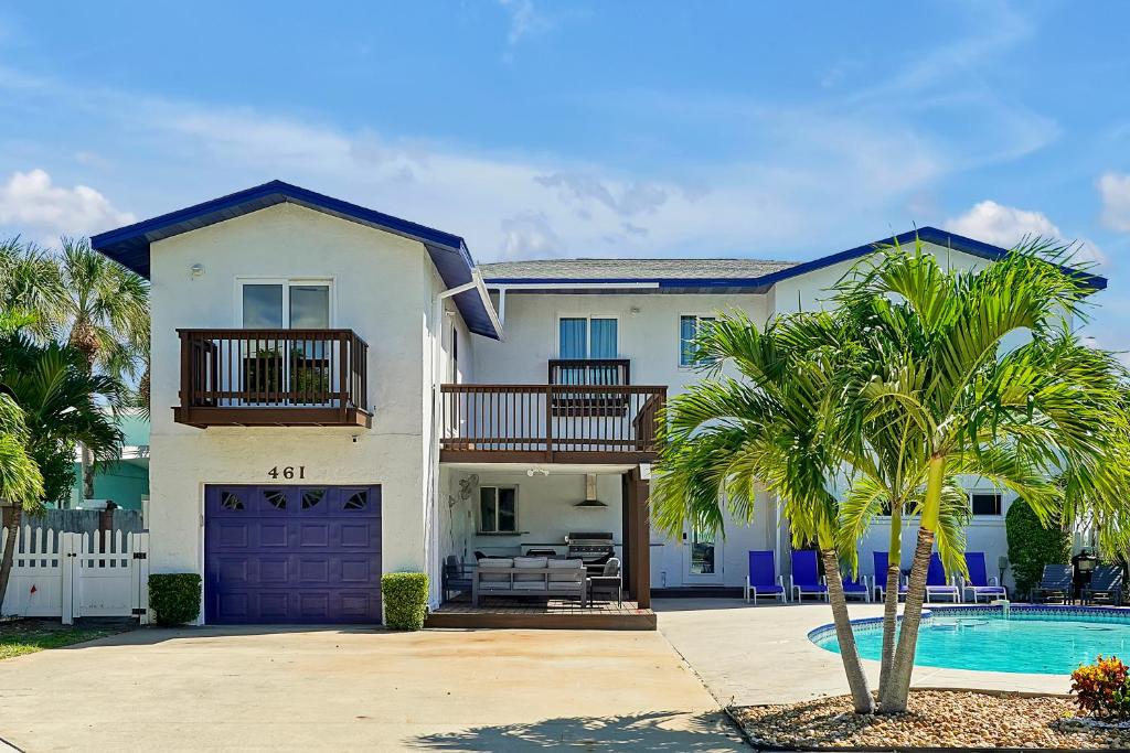 a large white house with a pool and palm trees at Villa with Beach Front Views in Cocoa Beach