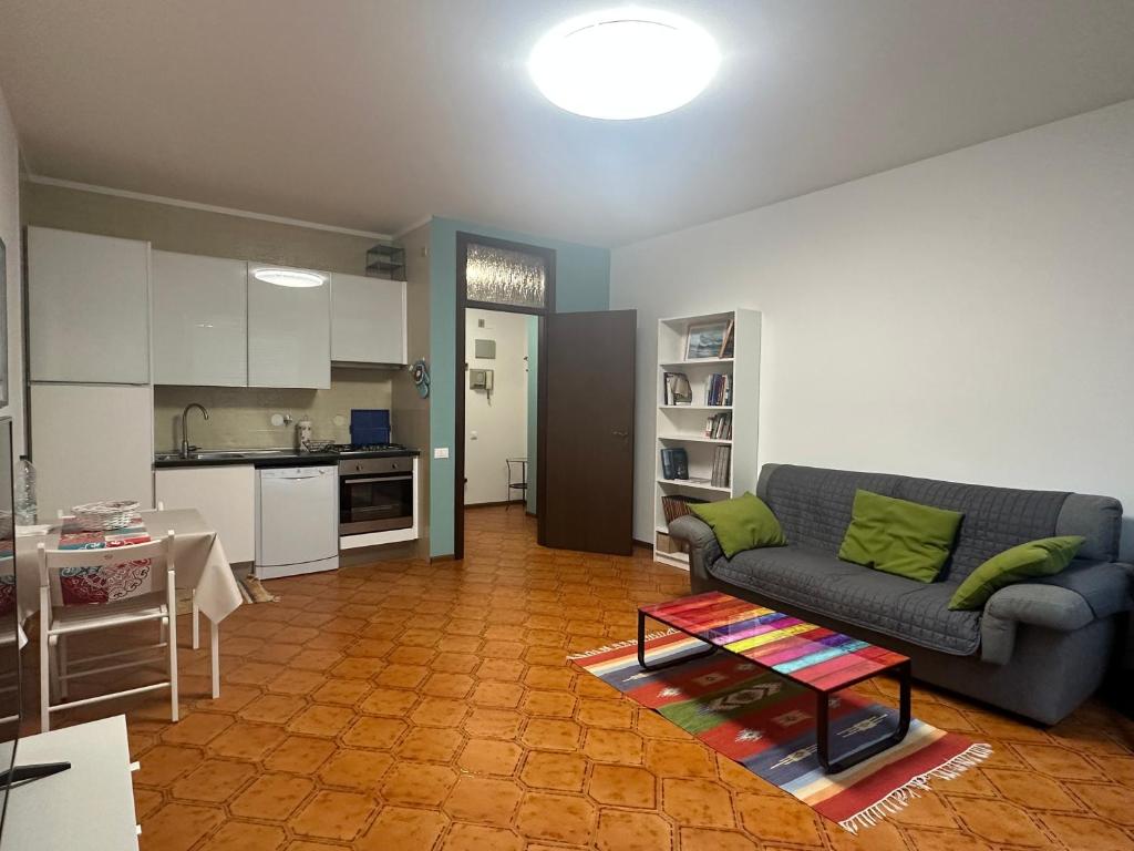 Una sala de estar con un sofá y una cocina. en AURORA GARGEN IN CENTRO, en Trieste