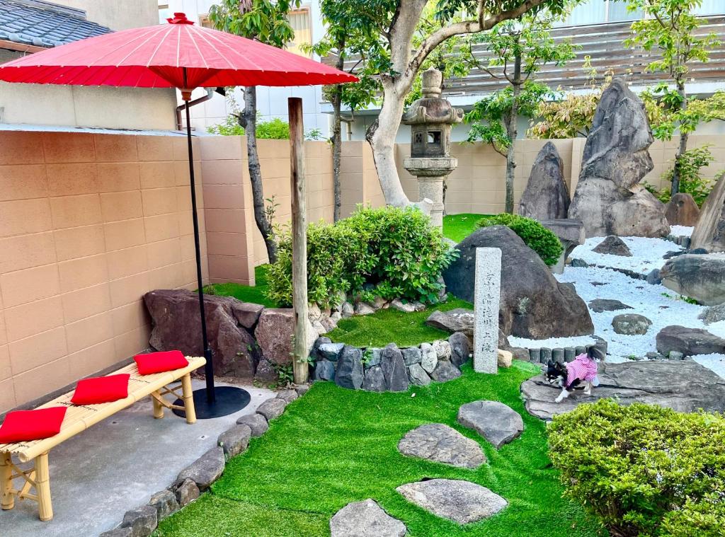 un jardín con banco y sombrilla en 民泊Murakami International, en Kishiwada