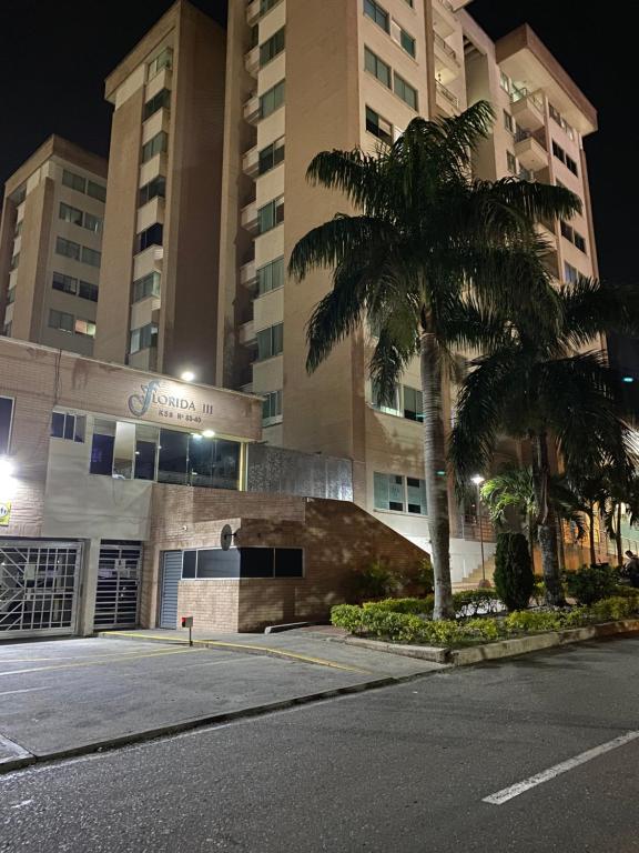 une rue vide en face d'un bâtiment avec un palmier dans l'établissement Apartamento completo, à Ibagué