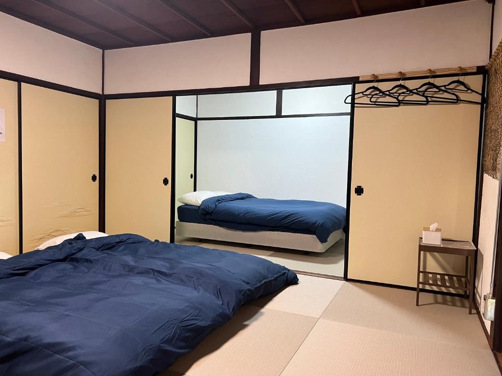 a bedroom with two beds in it with a mirror at The Pine 京都嵐山 in Kyoto