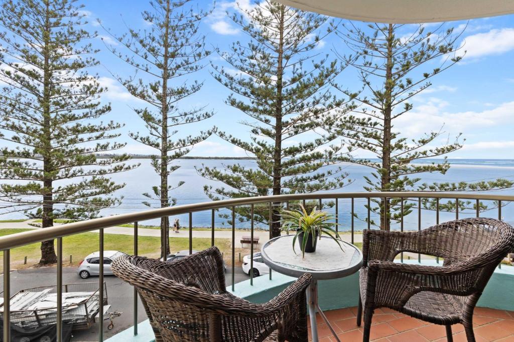 a balcony with a table and chairs and a view of the ocean at Eastbourne U6 80 Esplanade Golden Beach in Caloundra