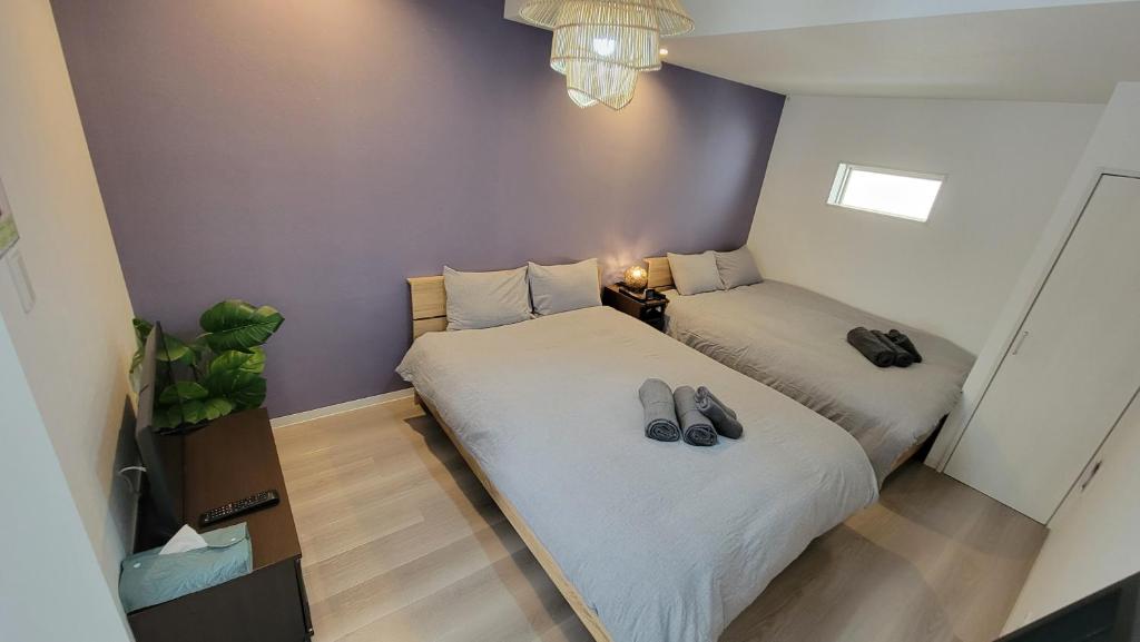 um quarto com duas camas com sapatos em Villa Feliz 101 em Tomari