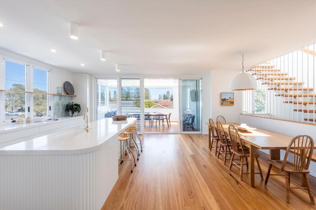 une cuisine et une salle à manger avec une table et des chaises dans l'établissement Sandhurst - oceanstays, à Yamba