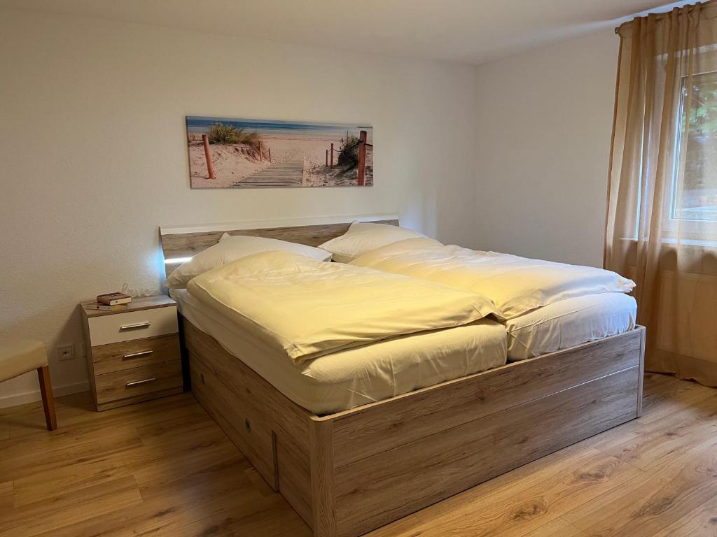 1 dormitorio con 1 cama grande con marco de madera en Ferienwohnung Oberursel, en Oberursel