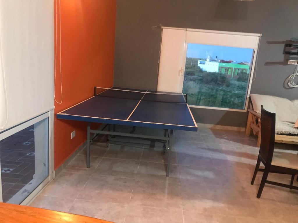 mesa de ping pong en la sala de estar con raqueta de ping pong en Casa La Loberia en La Lobería