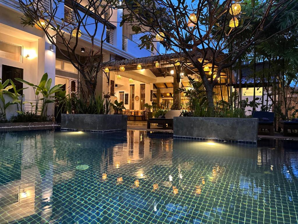 ein Schwimmbad in einem Haus mit Lichtern darin in der Unterkunft Babel Boutique in Siem Reap