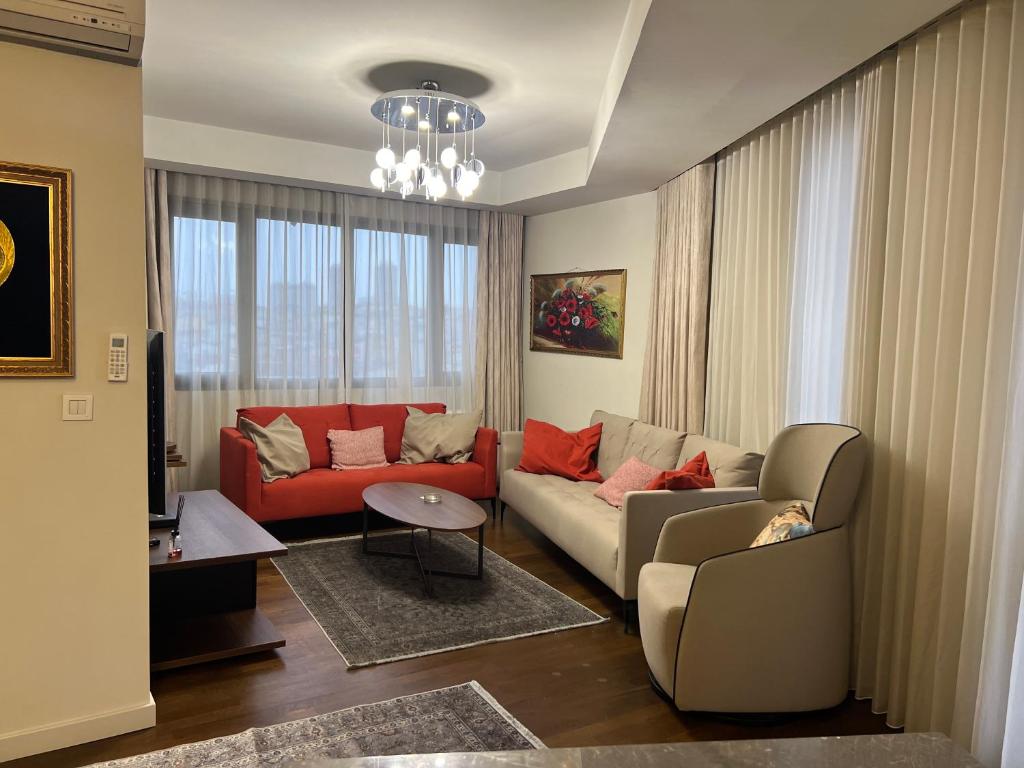 un soggiorno con 2 divani e un divano rosso di 4+1 daire a Istanbul