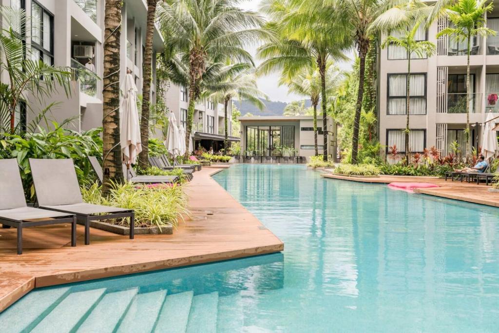 una piscina infinita en un complejo con palmeras en Diamond Condo by VС, en Bang Tao Beach