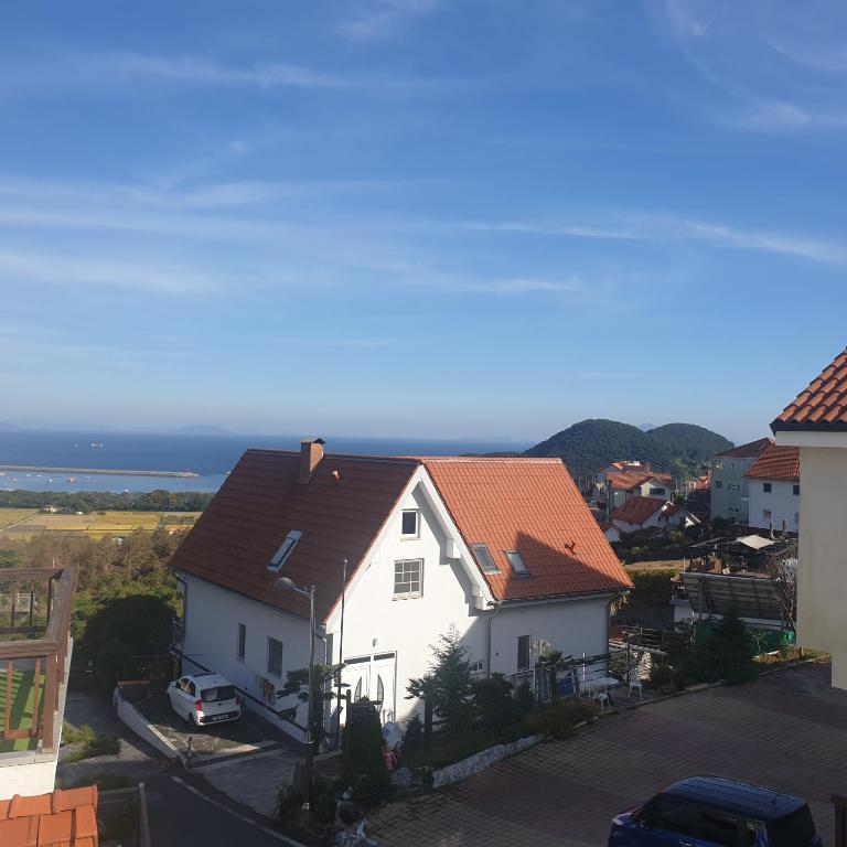 een wit huis met een rood dak bij Gutenberg house in Namhae