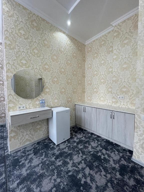 uma casa de banho com um lavatório e um espelho em IMAM AZAM HOTEL em Samarkand