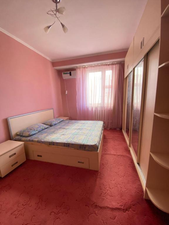 een slaapkamer met een bed en een raam bij Cozy corner right in the center! in Tasjkent