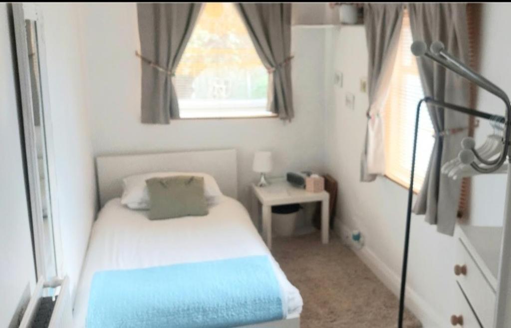 a small bedroom with a bed and a window at Centrel to london single bed room quiet home with host and breakfast in London