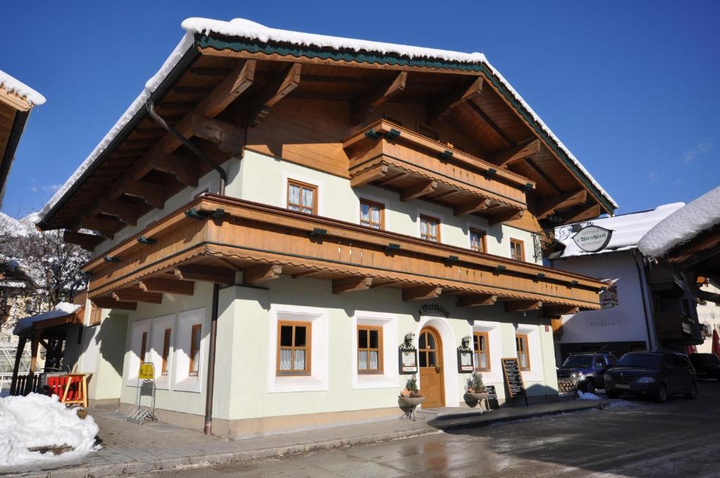 a large building with a wooden roof at Wirtshäusl Maria Alm in Maria Alm am Steinernen Meer