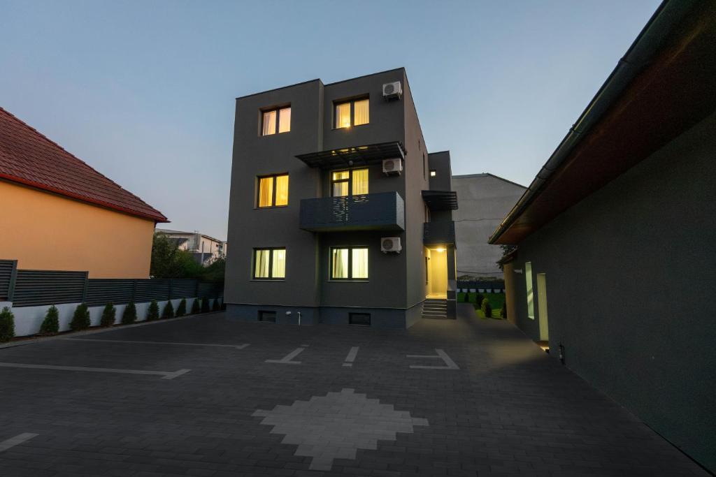 a building with lights on in a parking lot at Fit Residence in Cluj-Napoca