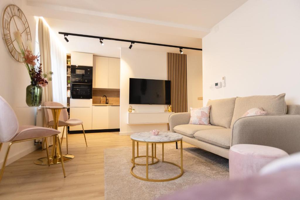 un soggiorno con un divano e un tavolo di Soho Boutique Apartman a Požega