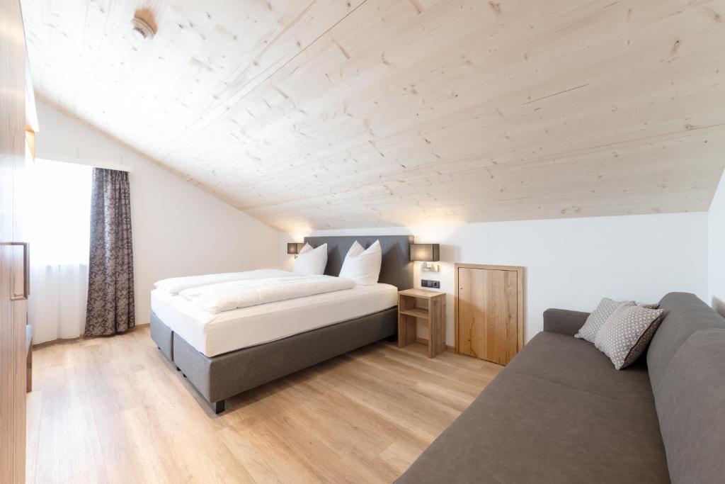 a bedroom with a bed and a couch at tannberg LODGE in Schröcken