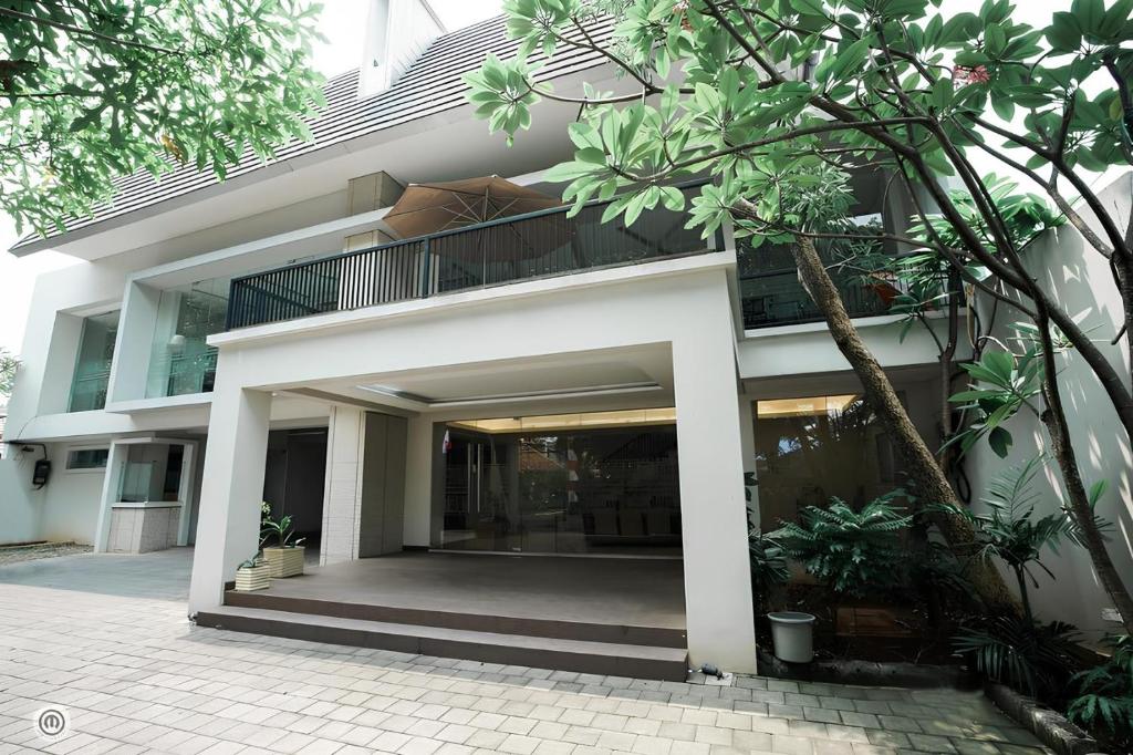 a white building with a balcony in front of it at ANNIE KUCA in Jakarta