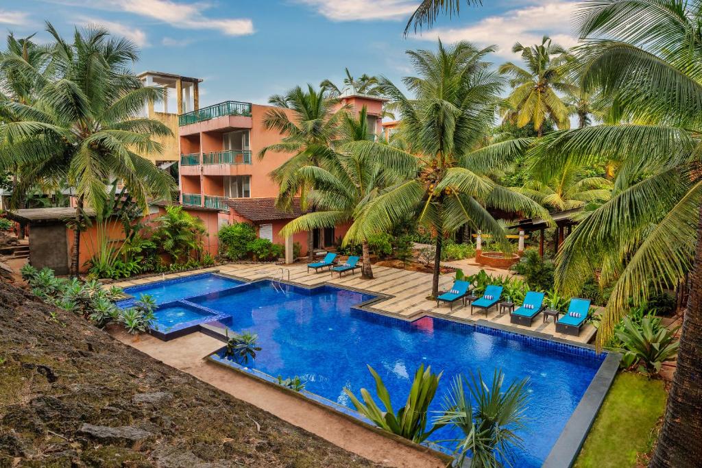 una imagen de un complejo con piscina y palmeras en Mandrem Beach Resort, a member of Radisson Individuals Retreat en Mandrem
