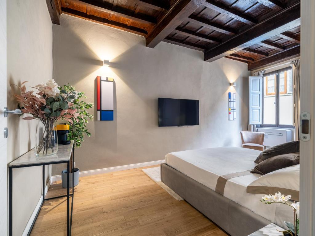 1 dormitorio con 1 cama y TV en la pared en Santa Croce Luxury Suite - Dolcevita Holiday en Florence