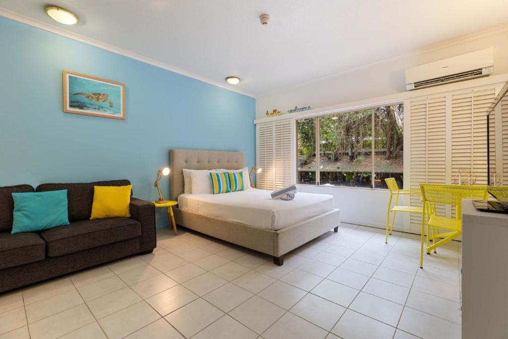 a living room with a couch and a table at Ramada Spacious Studio Apartment with Pool Views in Port Douglas