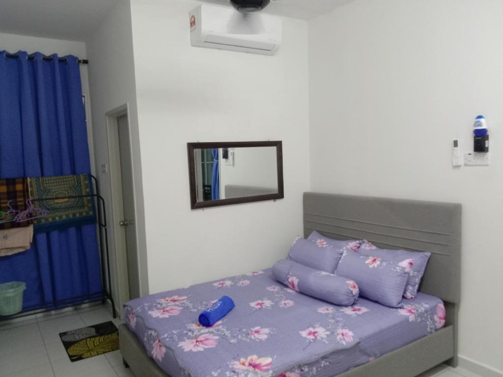 NADI HOMESTAY MELAKA في Air Molek: غرفة نوم مع سرير مع ملاءات أرجوانية ومرآة
