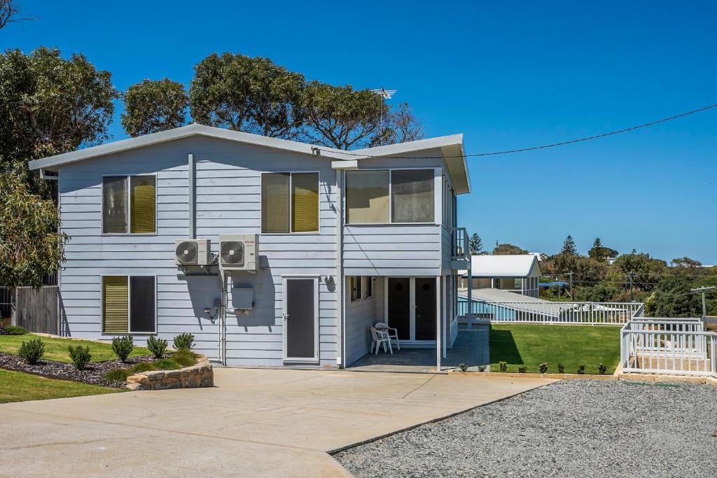una casa blanca con una entrada delante de ella en Seaclusion Cottage - Modern renovated beach house, en Guilderton