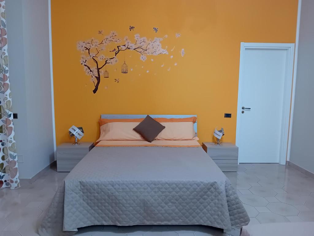 1 dormitorio con 1 cama con una pegatina de árbol en la pared en Al primo piano 22, en Castrovillari