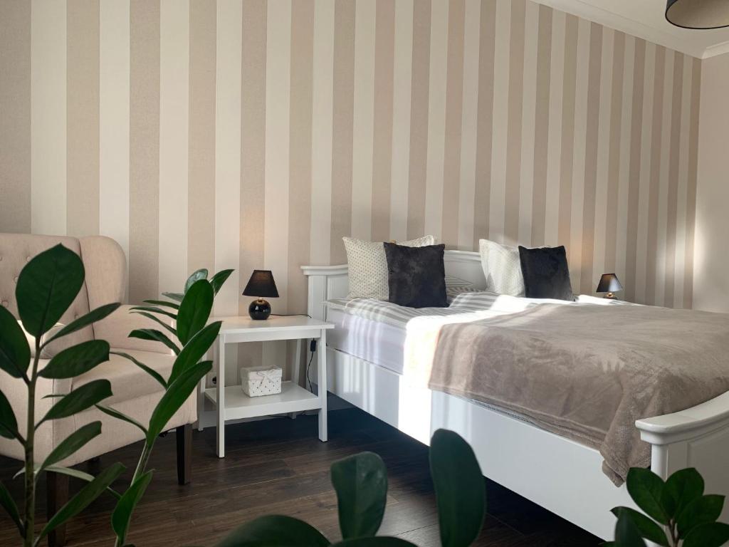 a bedroom with a white bed and striped walls at AquaGate Jurmala in Jūrmala