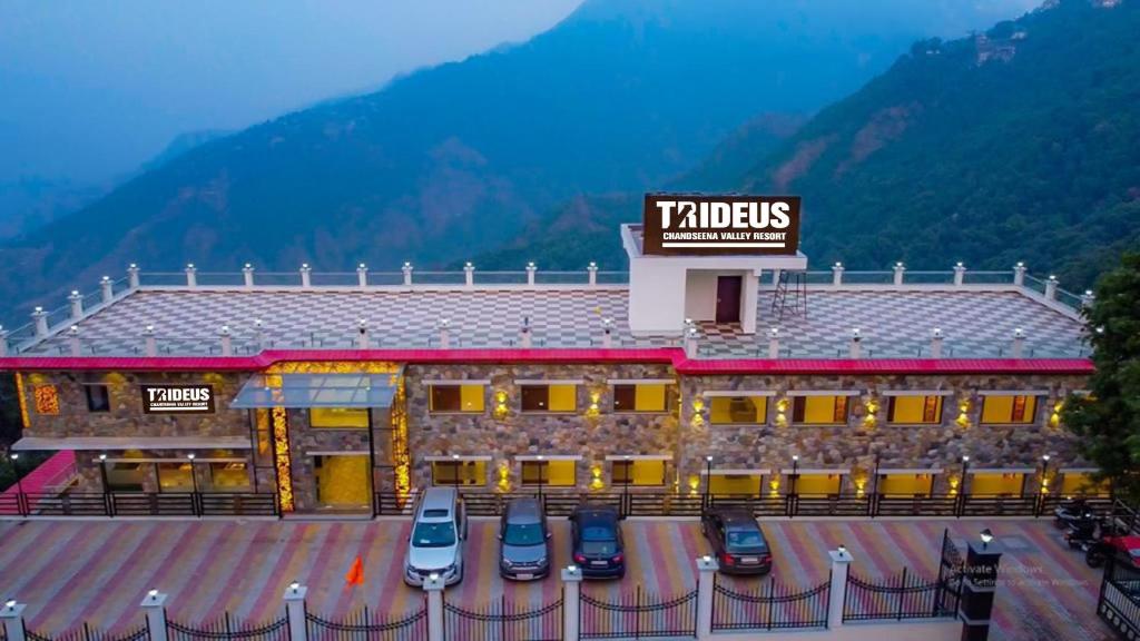 a hotel with cars parked in a parking lot at Trideus Chandseena Valley Resort in Mussoorie