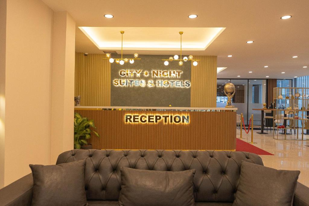 a lobby with a couch in front of a reception at City Night Suites & Hotels in Çekme