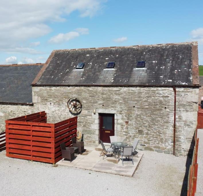 a brick building with a table and chairs in front of it at The Barn @ Clauchan holiday Cottages in Gatehouse of Fleet
