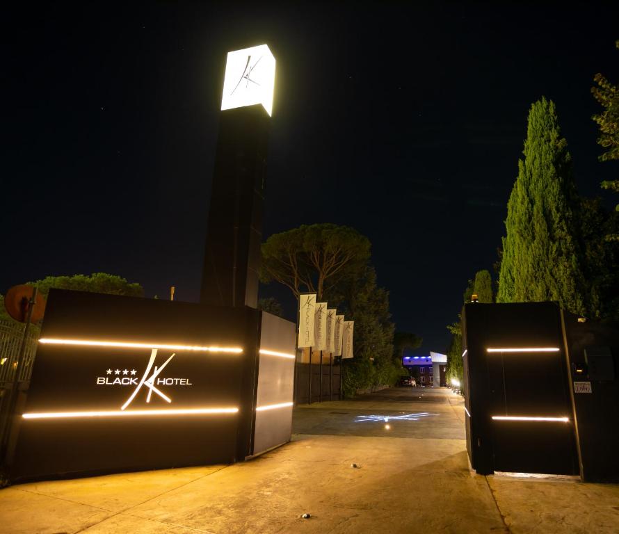 ein Straßenlicht und zwei Mülltonnen nachts in der Unterkunft Black Hotel in Rom