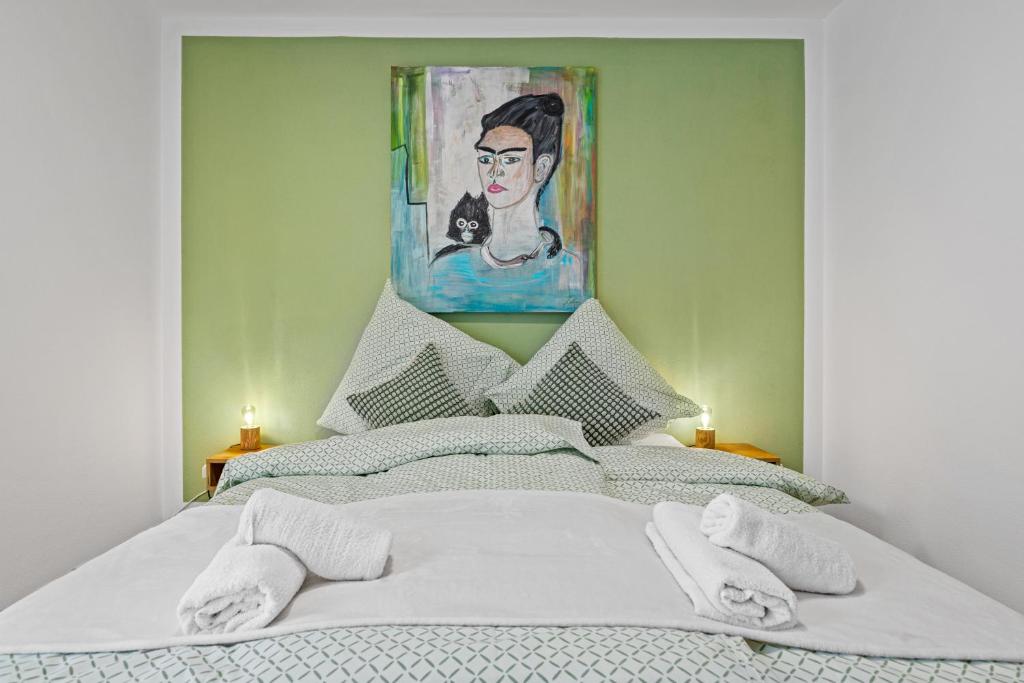 Un dormitorio con una cama con una pintura encima. en Smurmelhomes Oase: Terrasse - Parken - Kind, en Passau