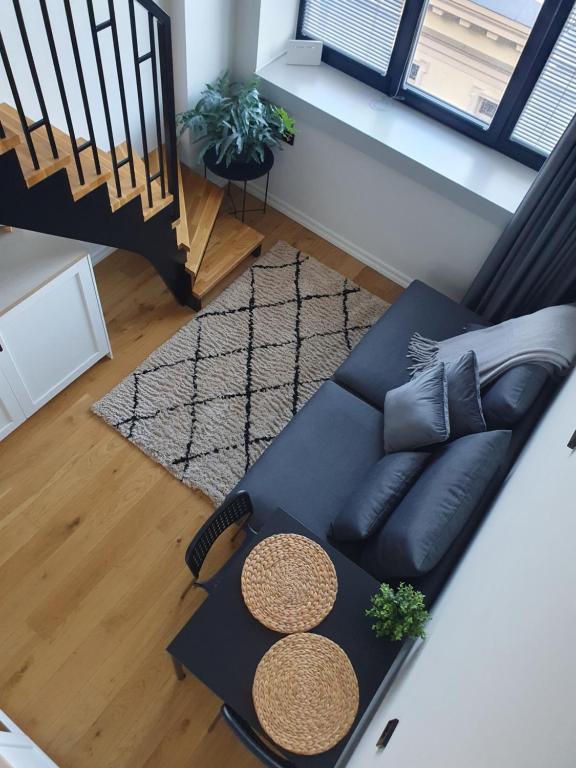 una vista aérea de una sala de estar con un sofá negro en Loft Style Studio Apartment- Free Parking- Free Gym- Keyless Access en Tartu