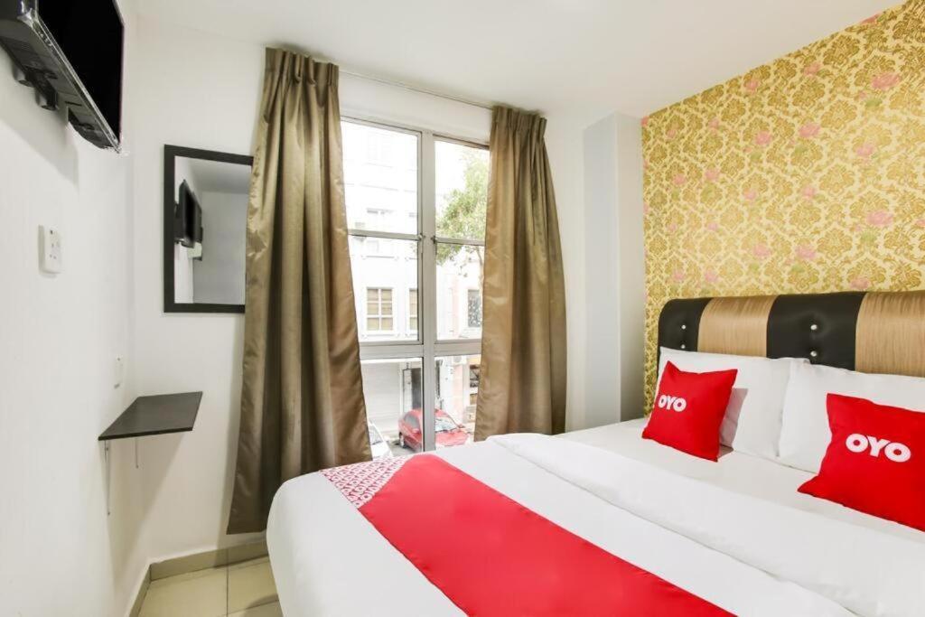 una camera d'albergo con un grande letto con cuscini rossi di NS INN Hotel a Malacca
