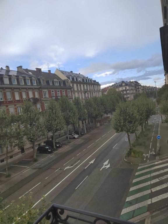 eine leere Straße in einer Stadt mit Gebäuden und Bäumen in der Unterkunft Appartement familial, calme et spacieux in Straßburg