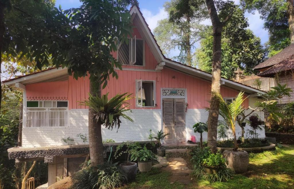 ein rotes Haus mit Bäumen davor in der Unterkunft Villa Celagi - Best View in Ubud and Huge Private Garden in Ubud