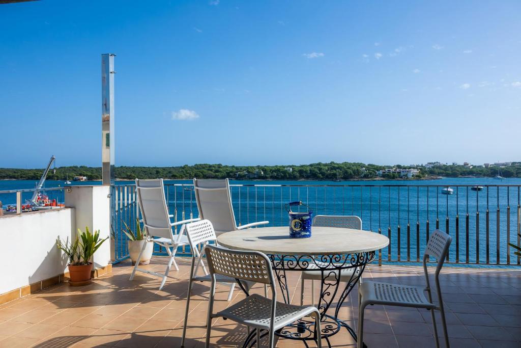 a table and chairs on a balcony with a view of the water at Varadero in Portocolom