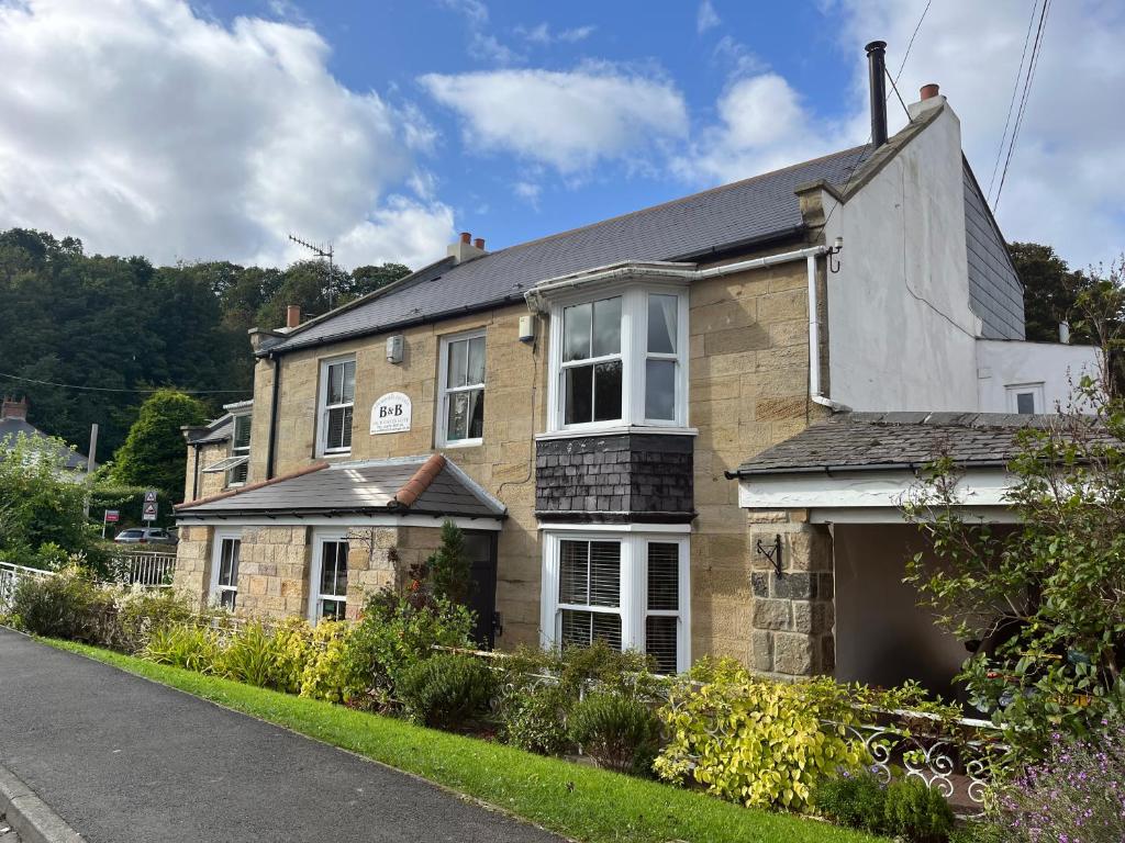 una casa di mattoni sul lato di una strada di Newminster Cottage a Morpeth