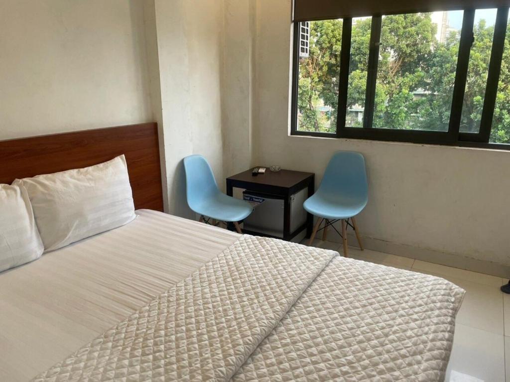 a bedroom with a bed and two chairs and a desk at YÊN HÒA MOTEL in Hanoi