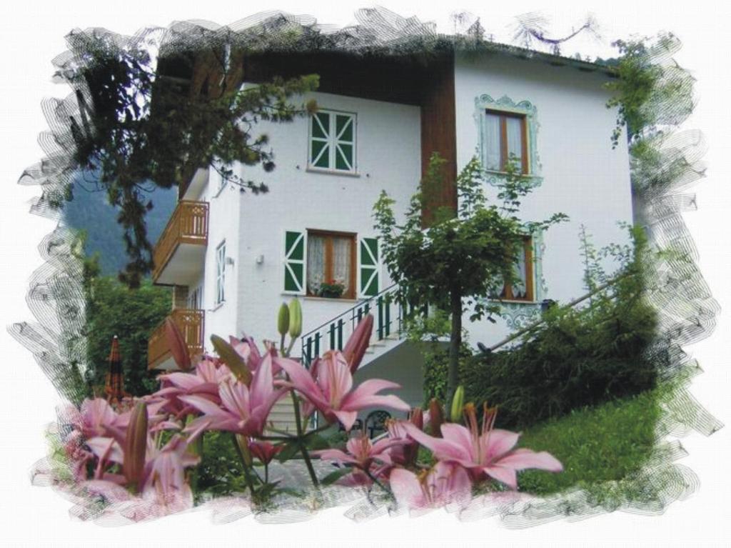 una casa con flores rosas delante de ella en Villa Aprica Appartamenti, en Molveno