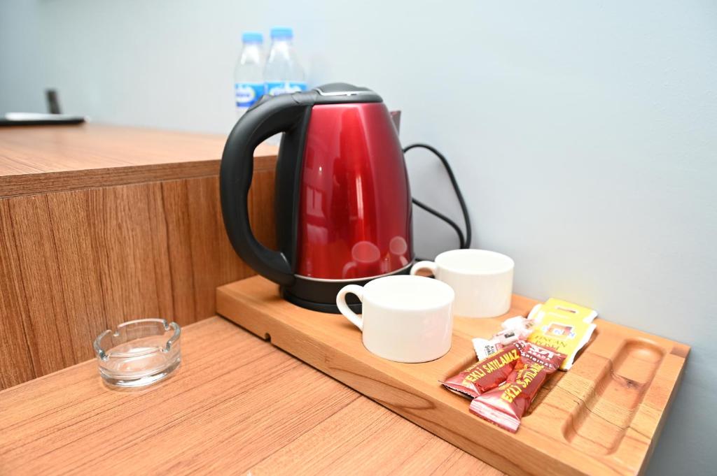 - Hervidor de té y tazas en una bandeja de madera en Asgard Hotel, en Beylikduzu