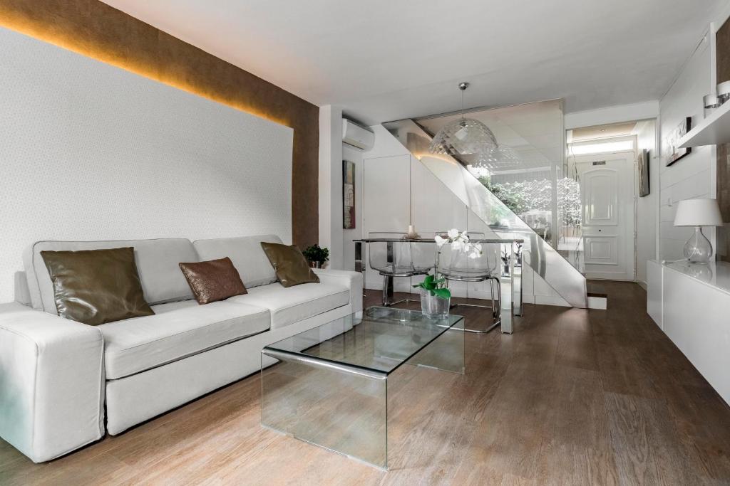 a living room with a white couch and a glass table at Chalet independiente de diseño con Patio Privado in Madrid