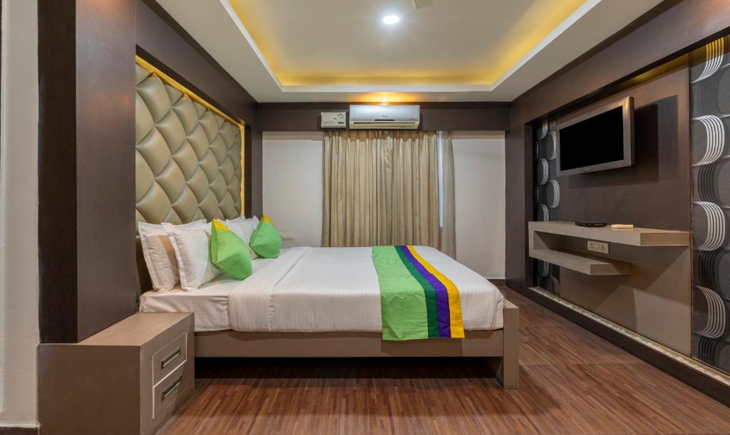 1 dormitorio con 1 cama y TV. en Treebo Trend Kings Orchid, en Bangalore