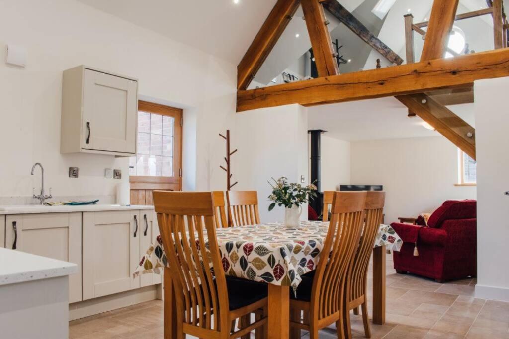 a kitchen and dining room with a table and chairs at 'The Dairy' - Nestled in a traditional farmyard. in Stourbridge